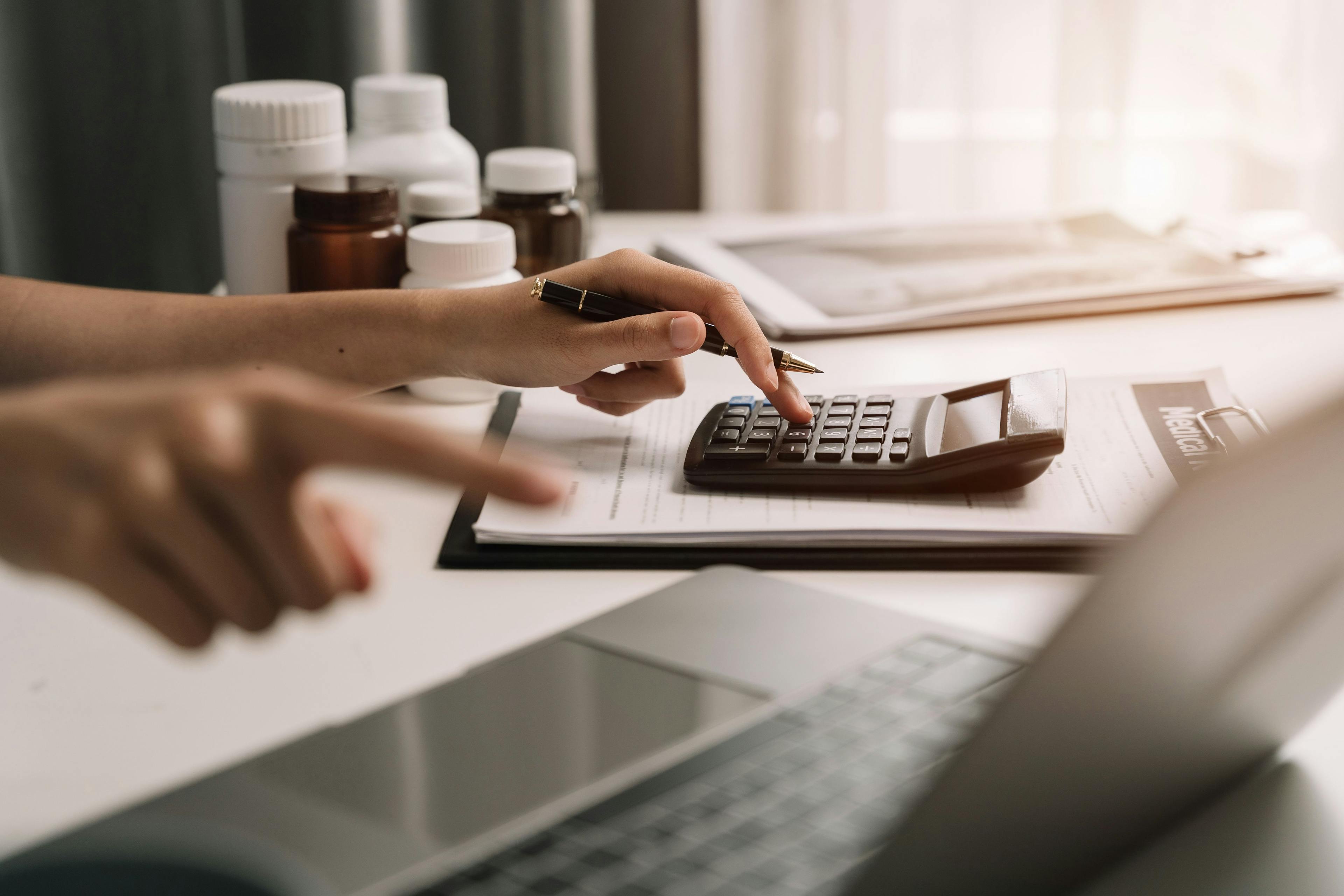 Pharmacist uses a service fee calculator to calculate drug reimbursement, financials