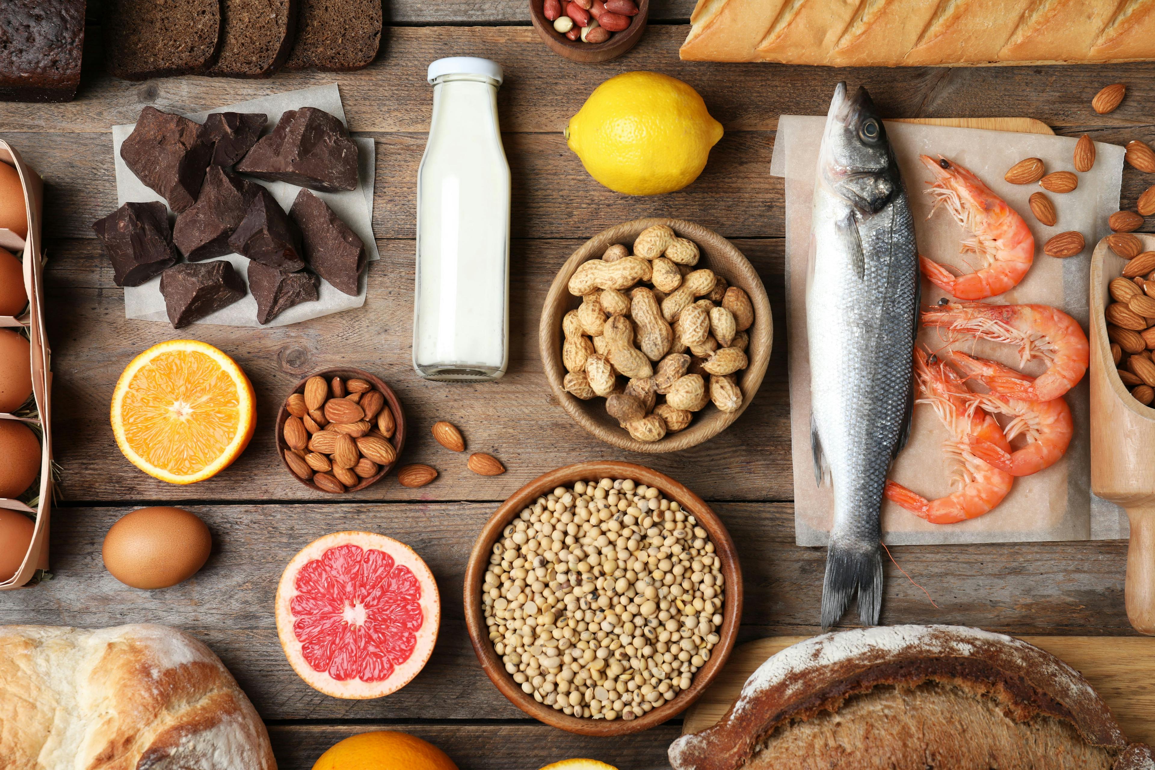 Flat lay composition of different products on wooden table. Food allergy concept - Image credit: New Africa | stock.adobe.com