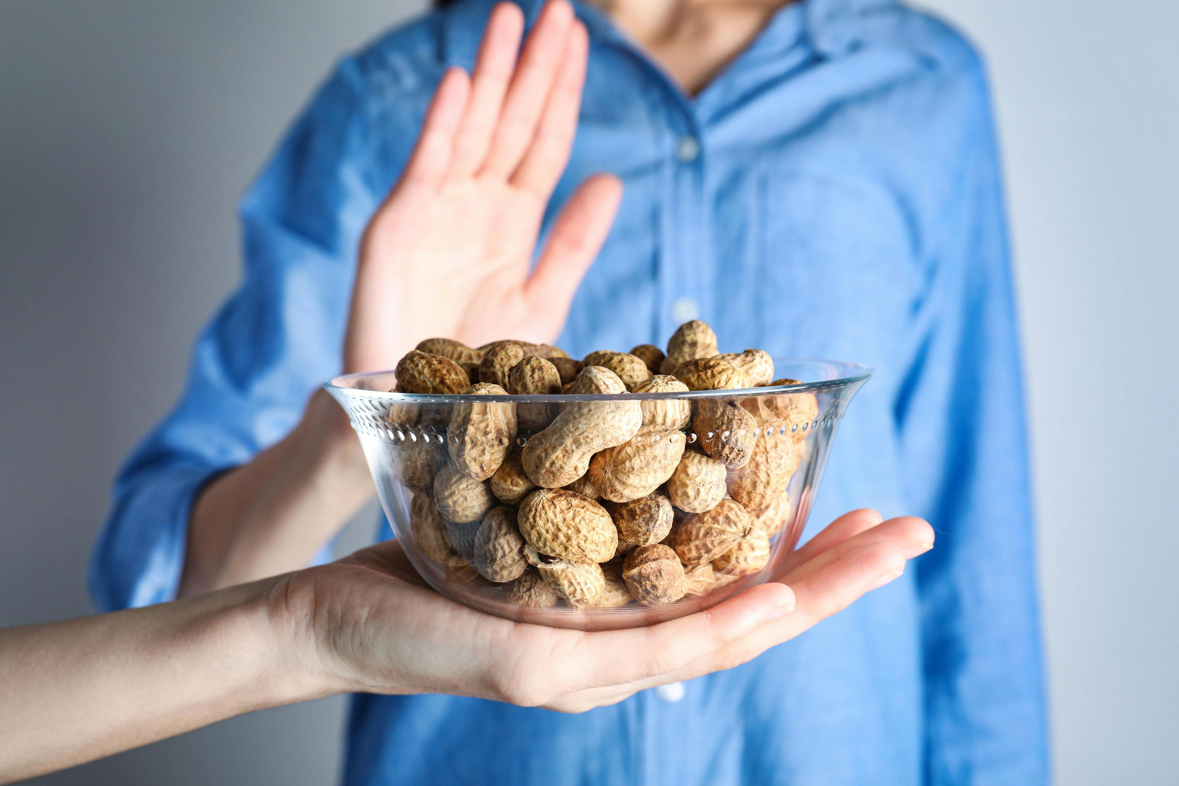 Woman refusing to eat peanuts, closeup. Food allergy concept | Image Credit: New Africa - stock.adobe.com