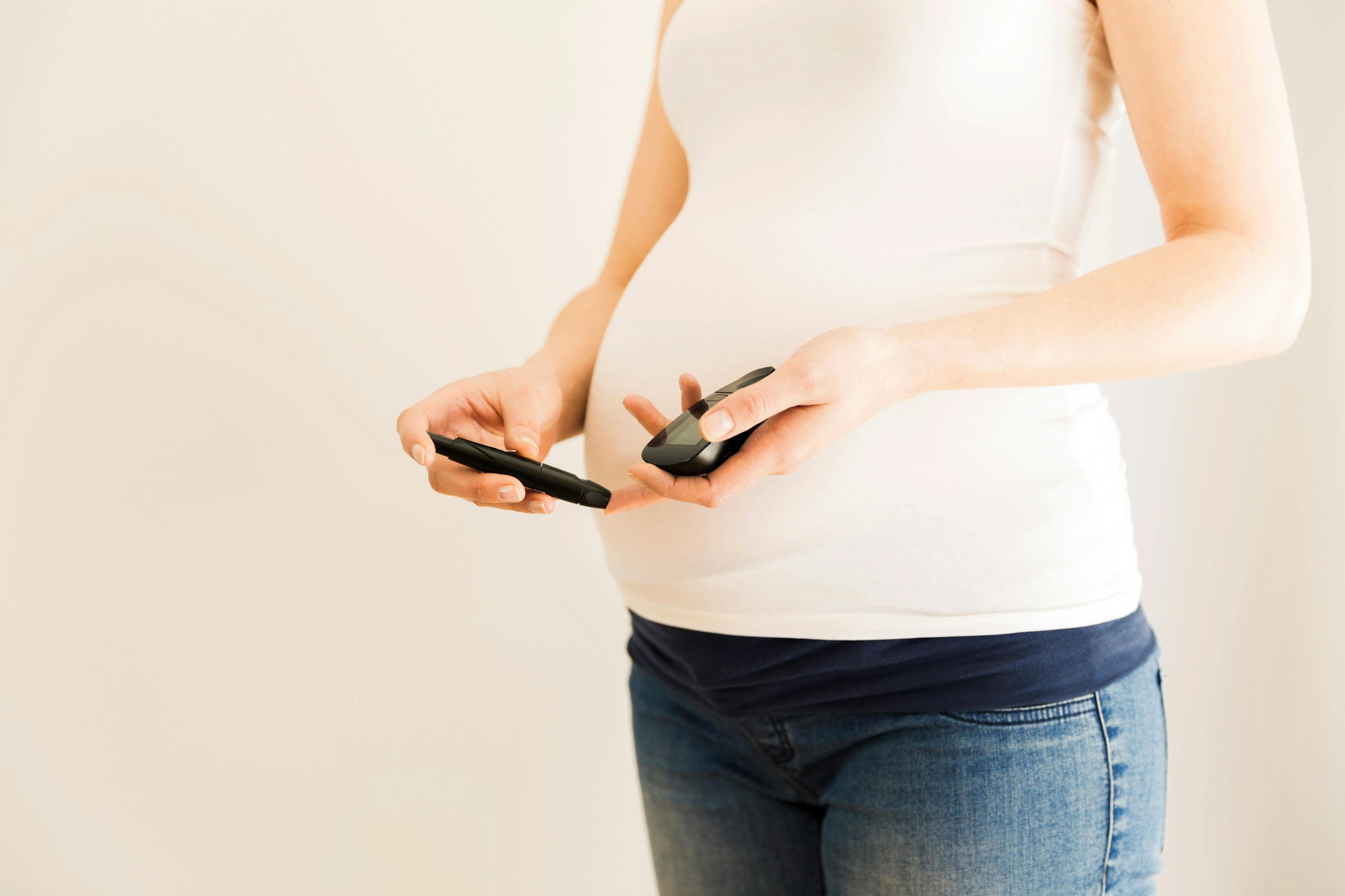 Pregnant woman checking blood sugar level. Gestational diabetes. Pregnancy health