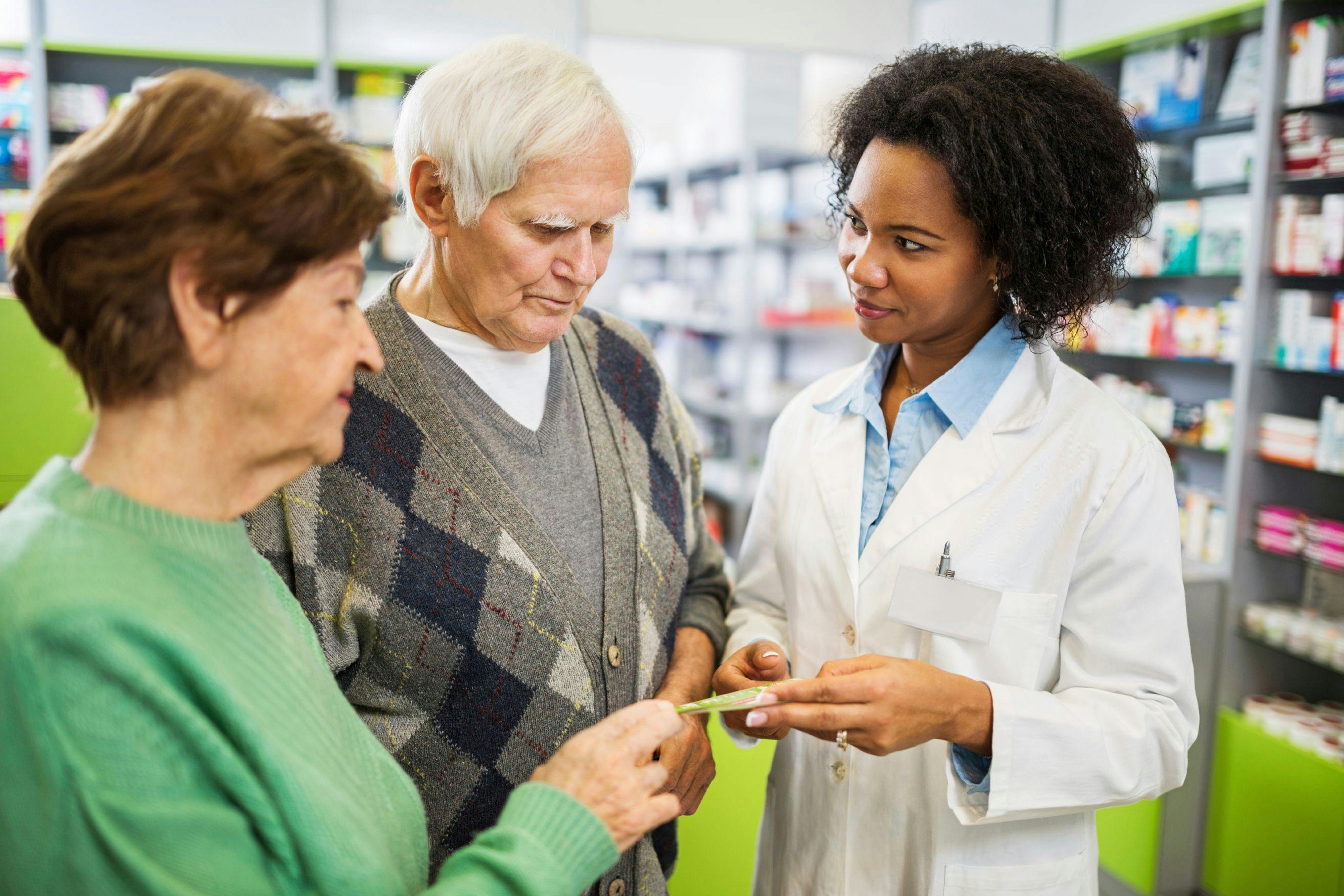 Pharmacist assisting older couple