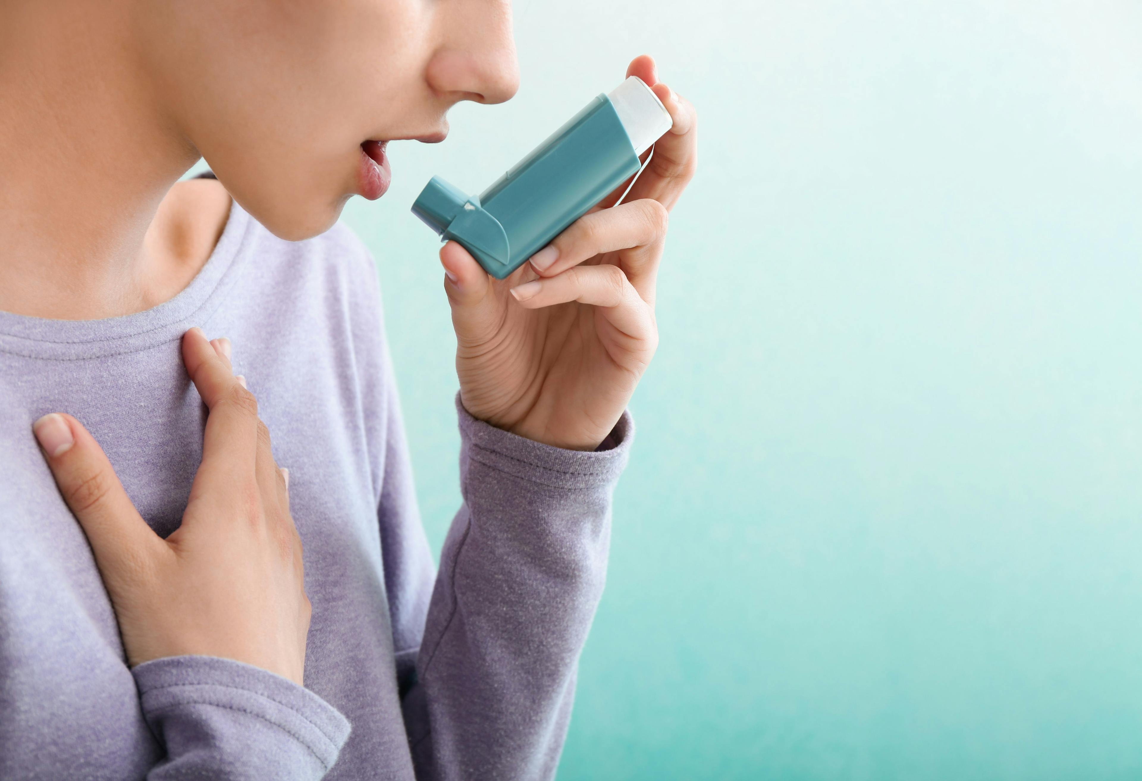 Woman using an asthma inhaler | Image credit: Pixel-Shot | stock.adobe.com