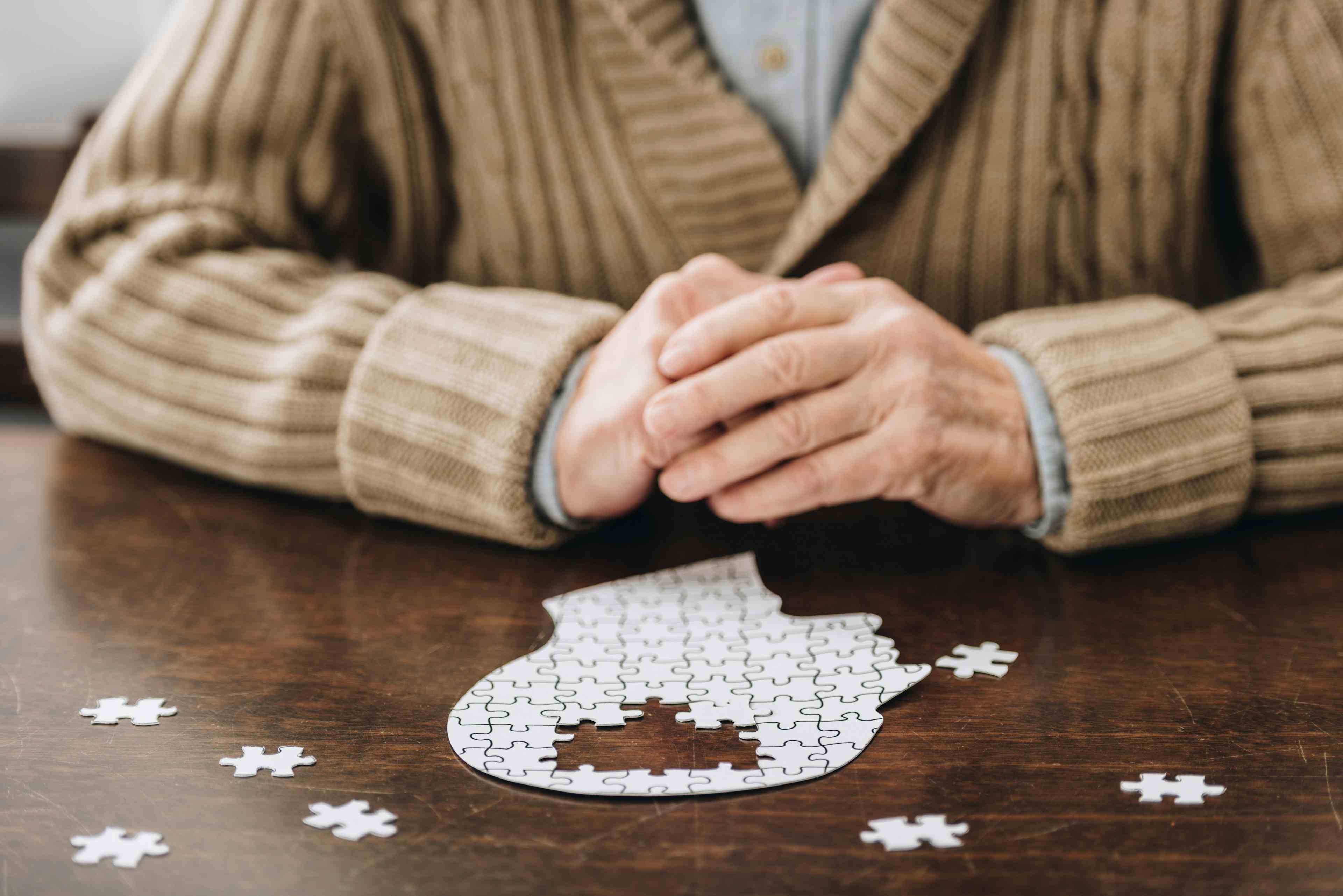Cropped view of senior man playing with puzzles on table- Image credit: LIGHTFIELD STUDIOS | stock.adobe.com