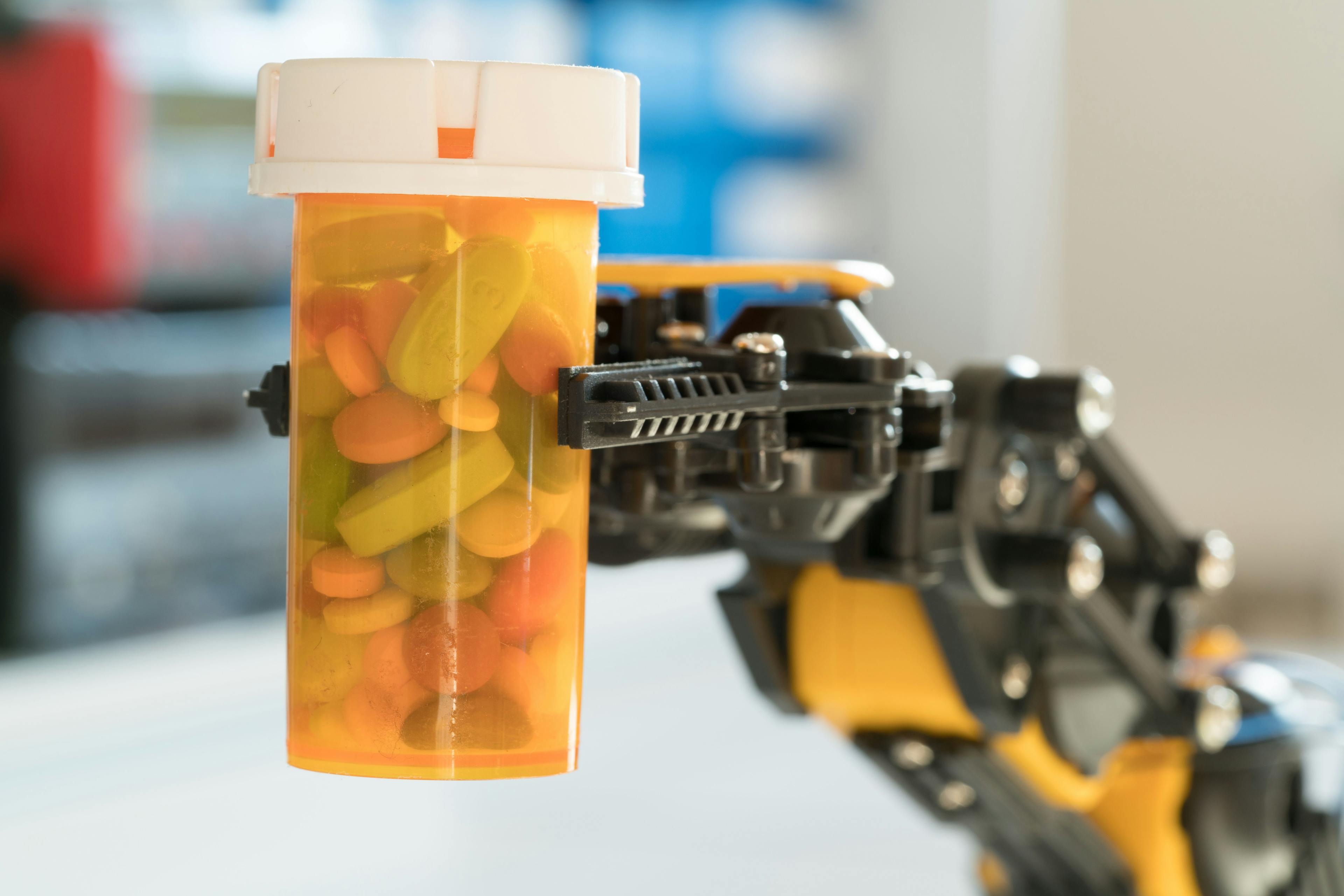 robot arm holds a bottle of pills