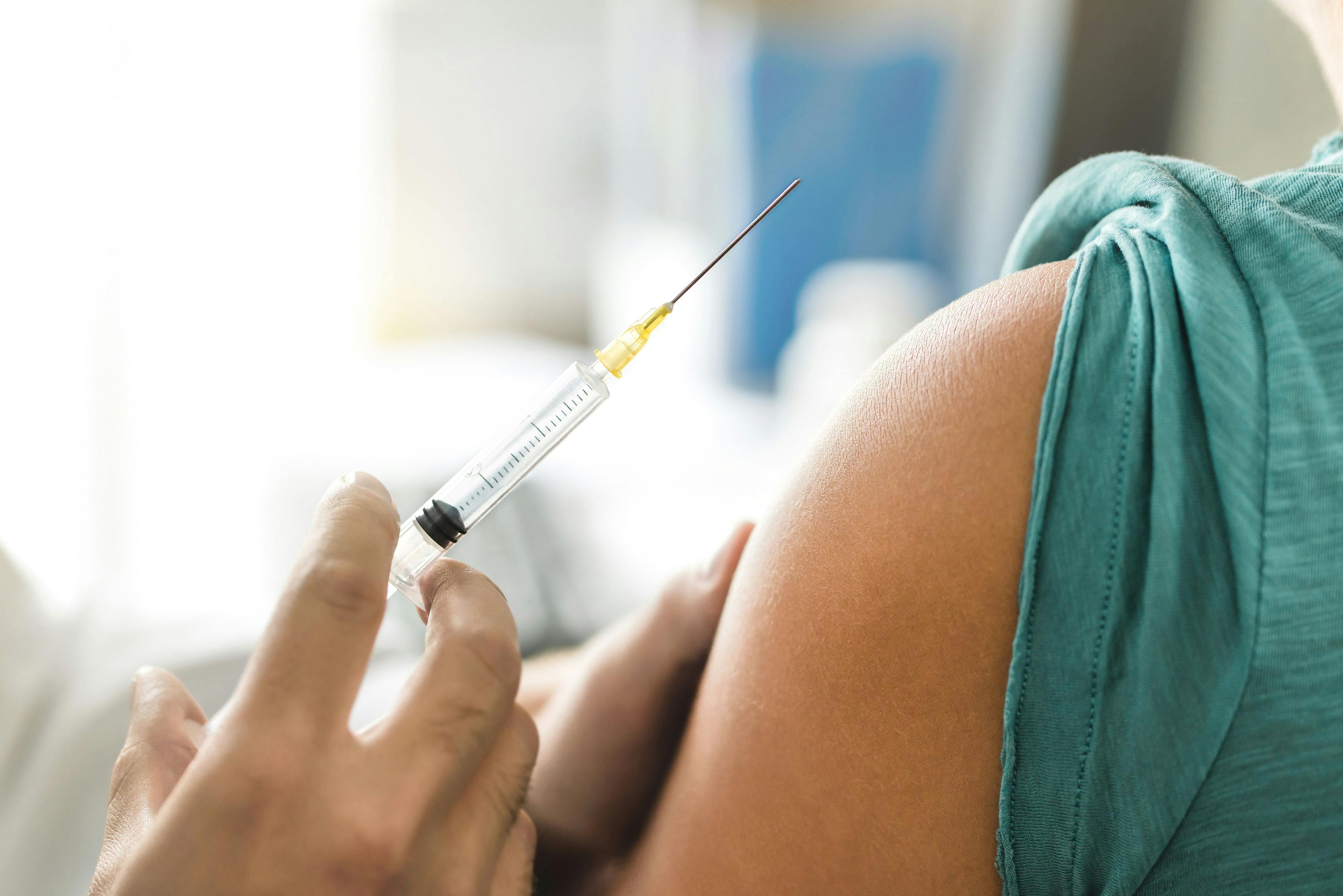 Vaccine or flu shot in injection needle. Doctor working with patient's arm. Physician or nurse giving vaccination and immunity to virus, influenza or HPV with syringe. Appointment with medical expert. | Image Credit: terovesalainen - stock.adobe.com