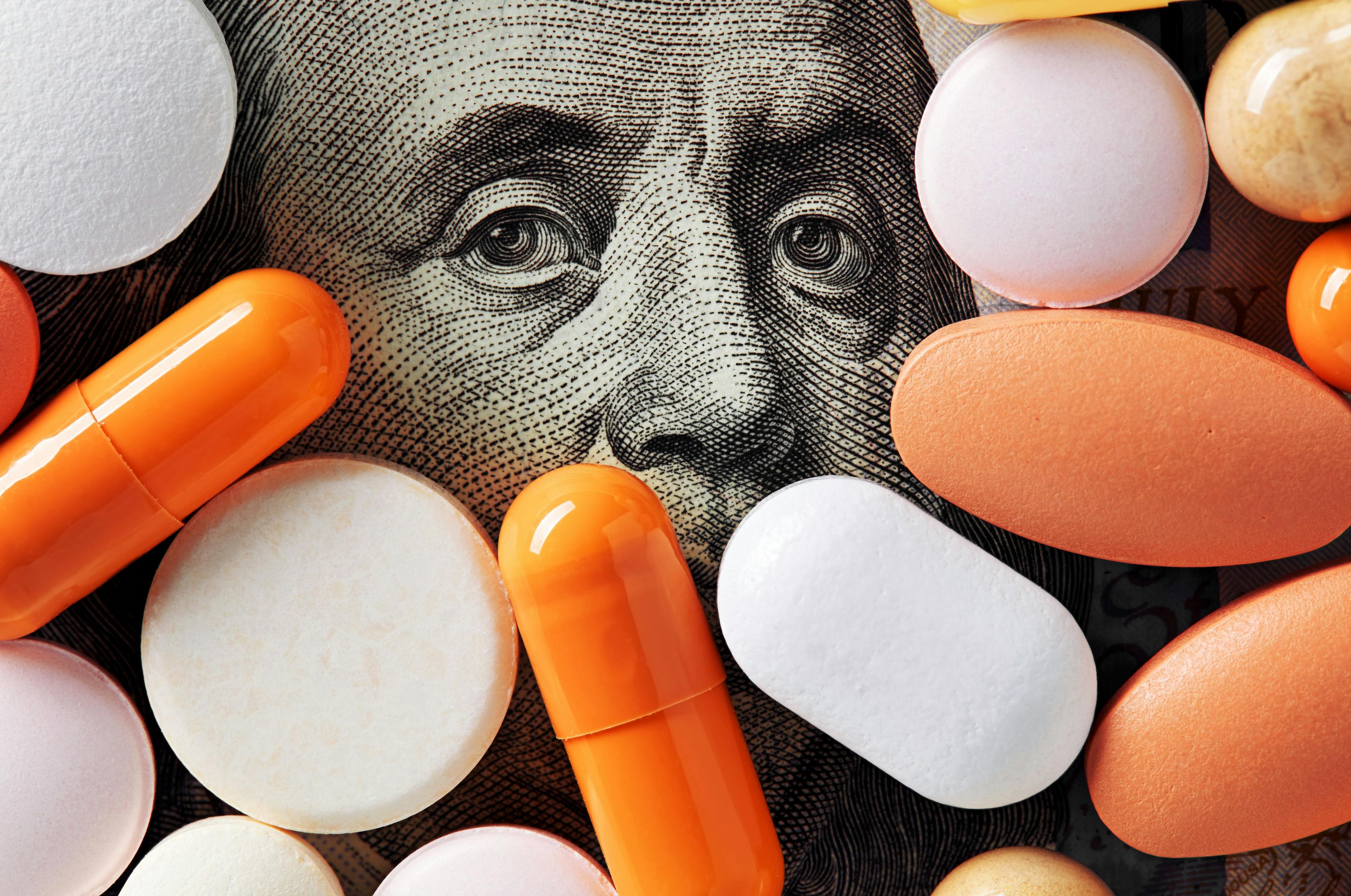 Pills on a background of a one hundred American dollar bill | Image credit: Cagkan - stock.adobe.com