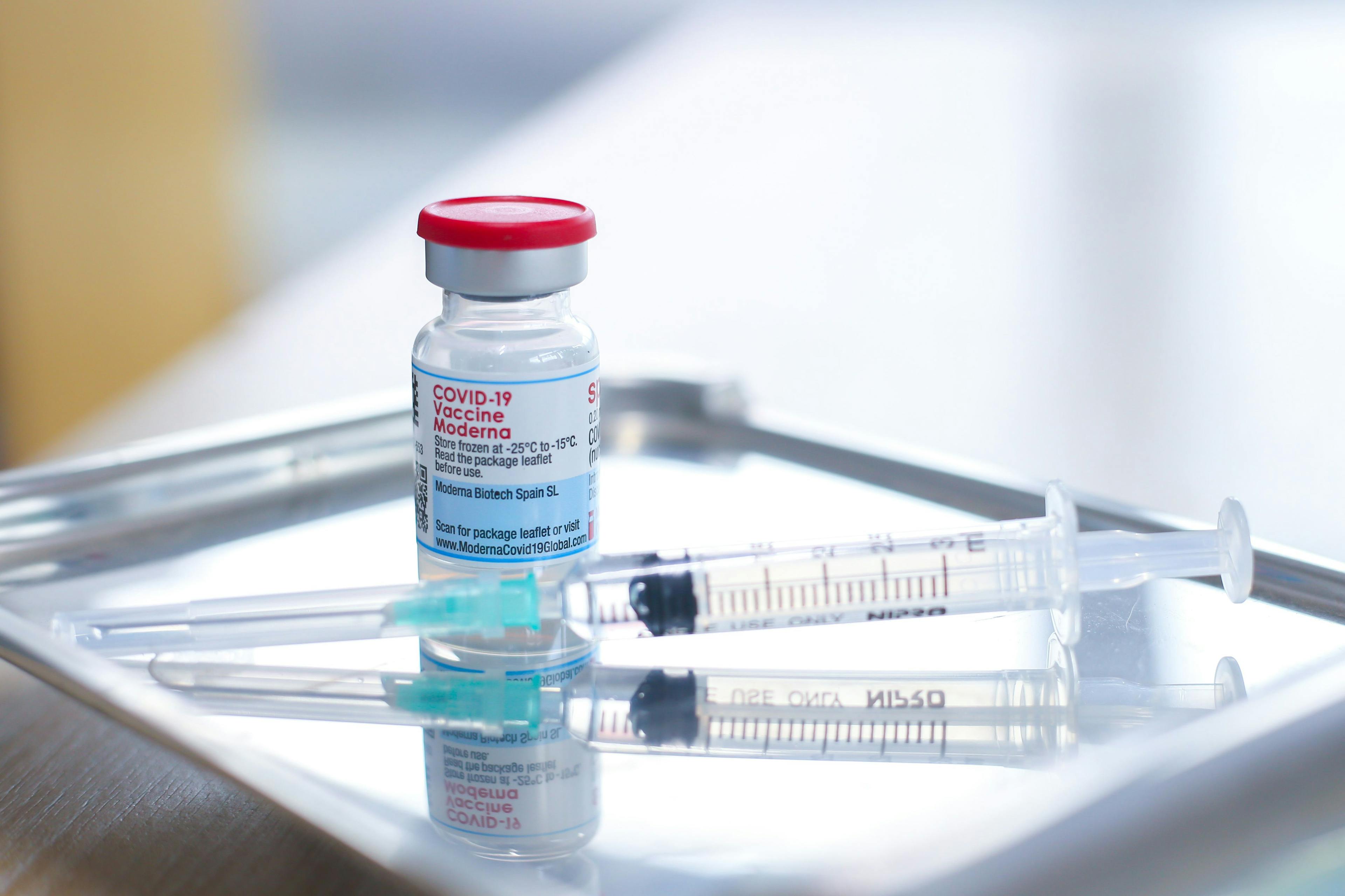 Closeup of biontech pfizer and moderna spikevax mrna covid-19 vaccine vials.