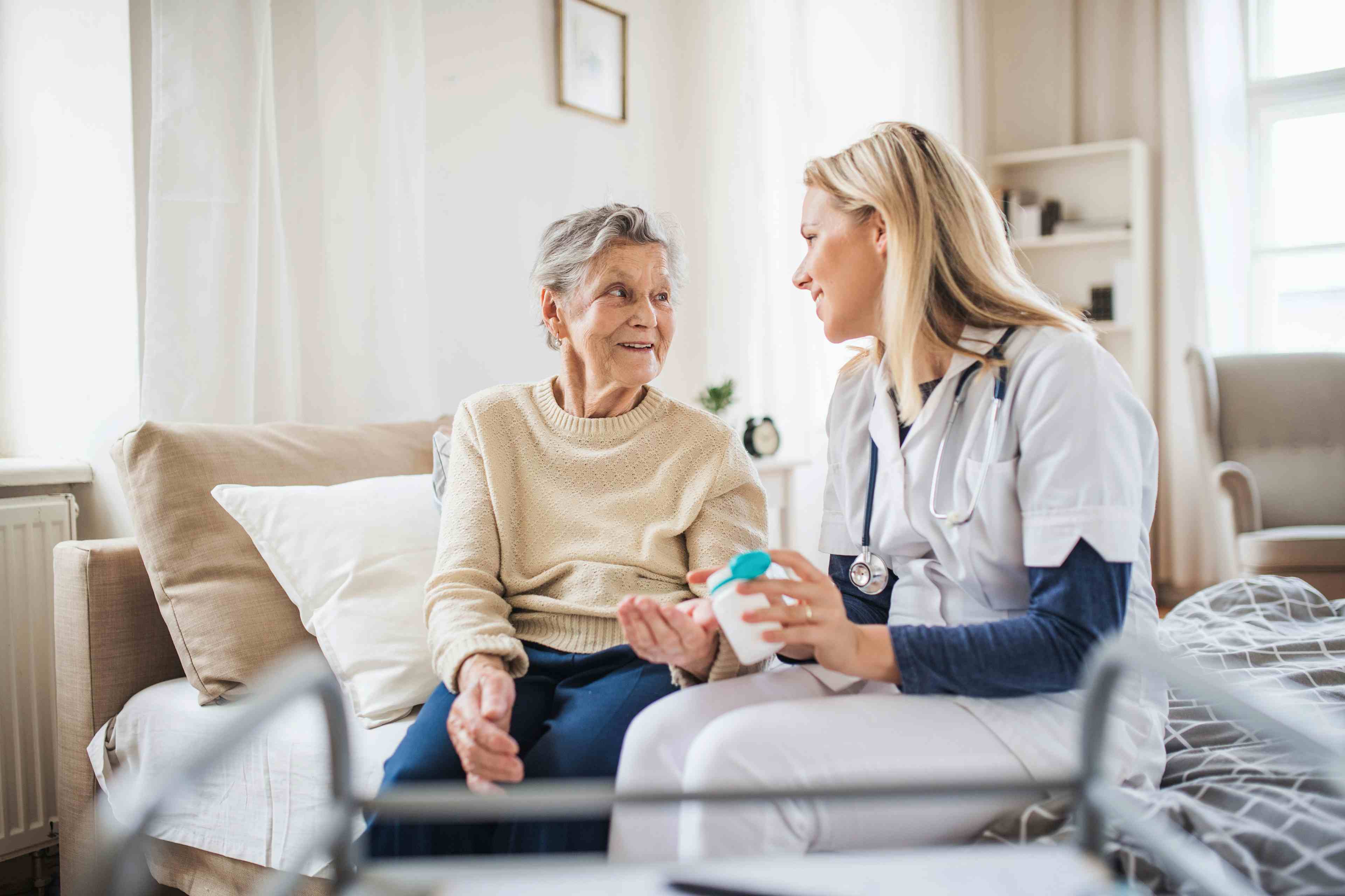 A health visitor explaining a senior woman how to take pills - Image credit: Halfpoint | stock.adobe.com 