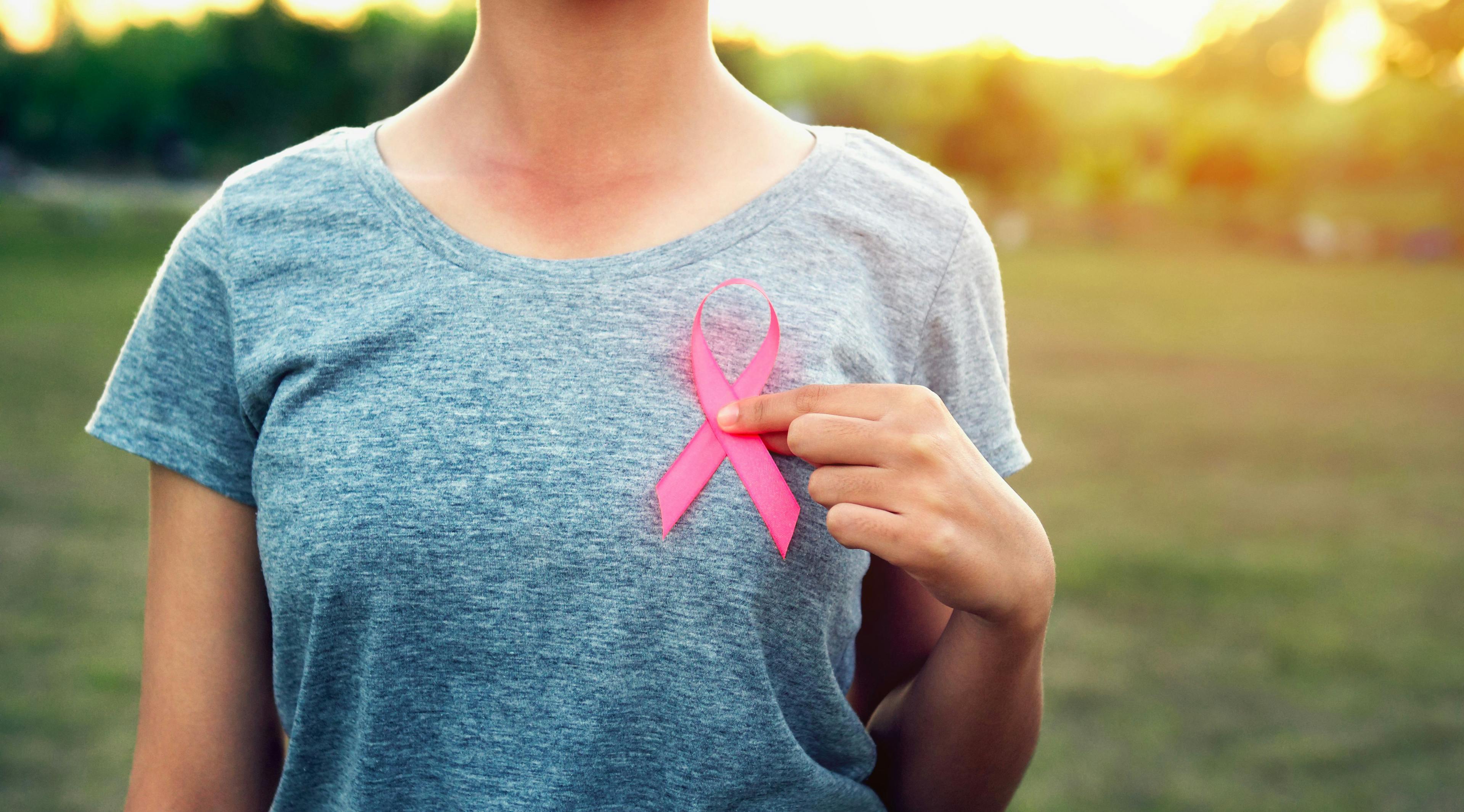 Woman holding a pink ribbon for breast cancer awareness