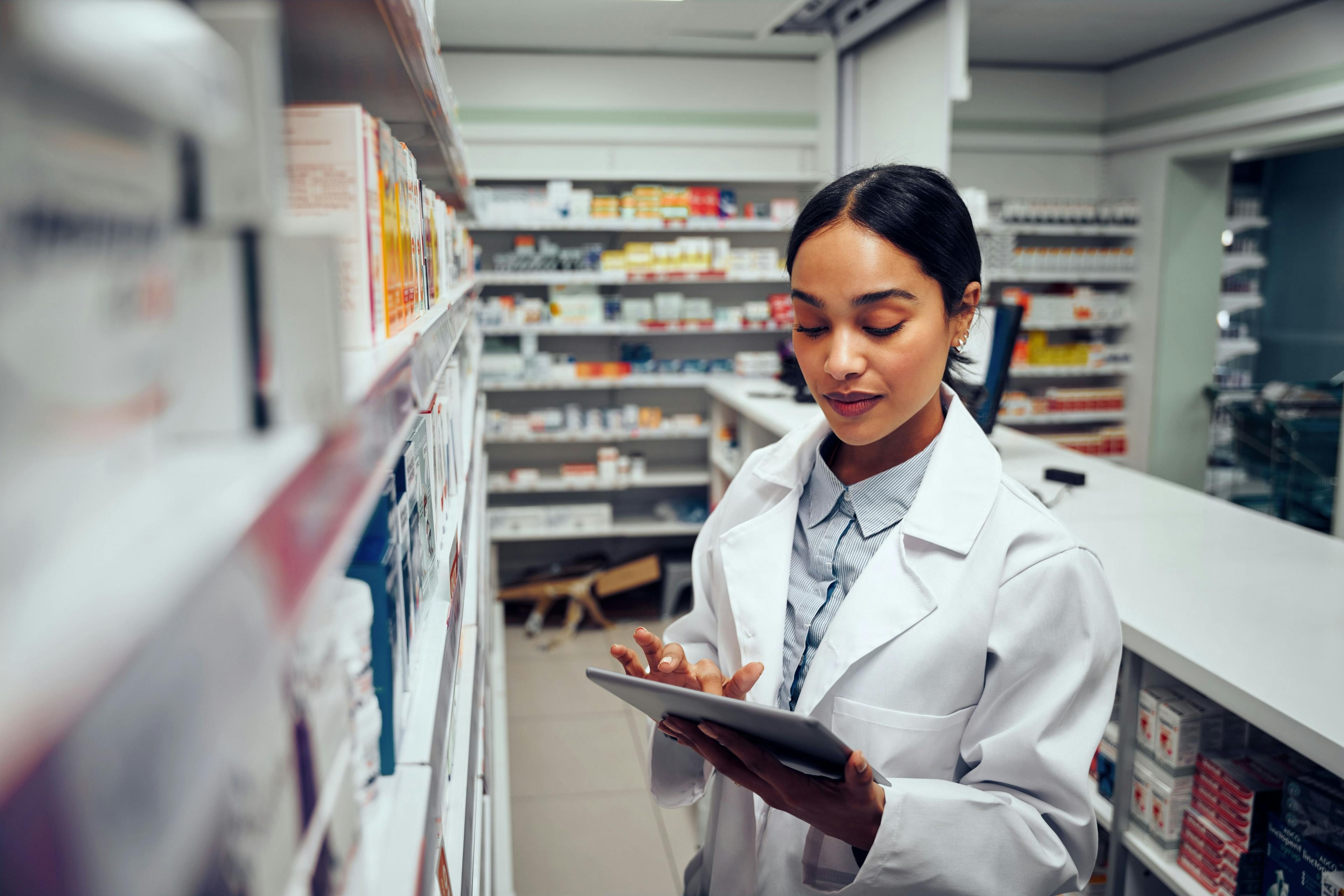 Young female pharmacist checking inventory of medicines in pharmacy | Image Credit: StratfordProductions - stock.adobe.com