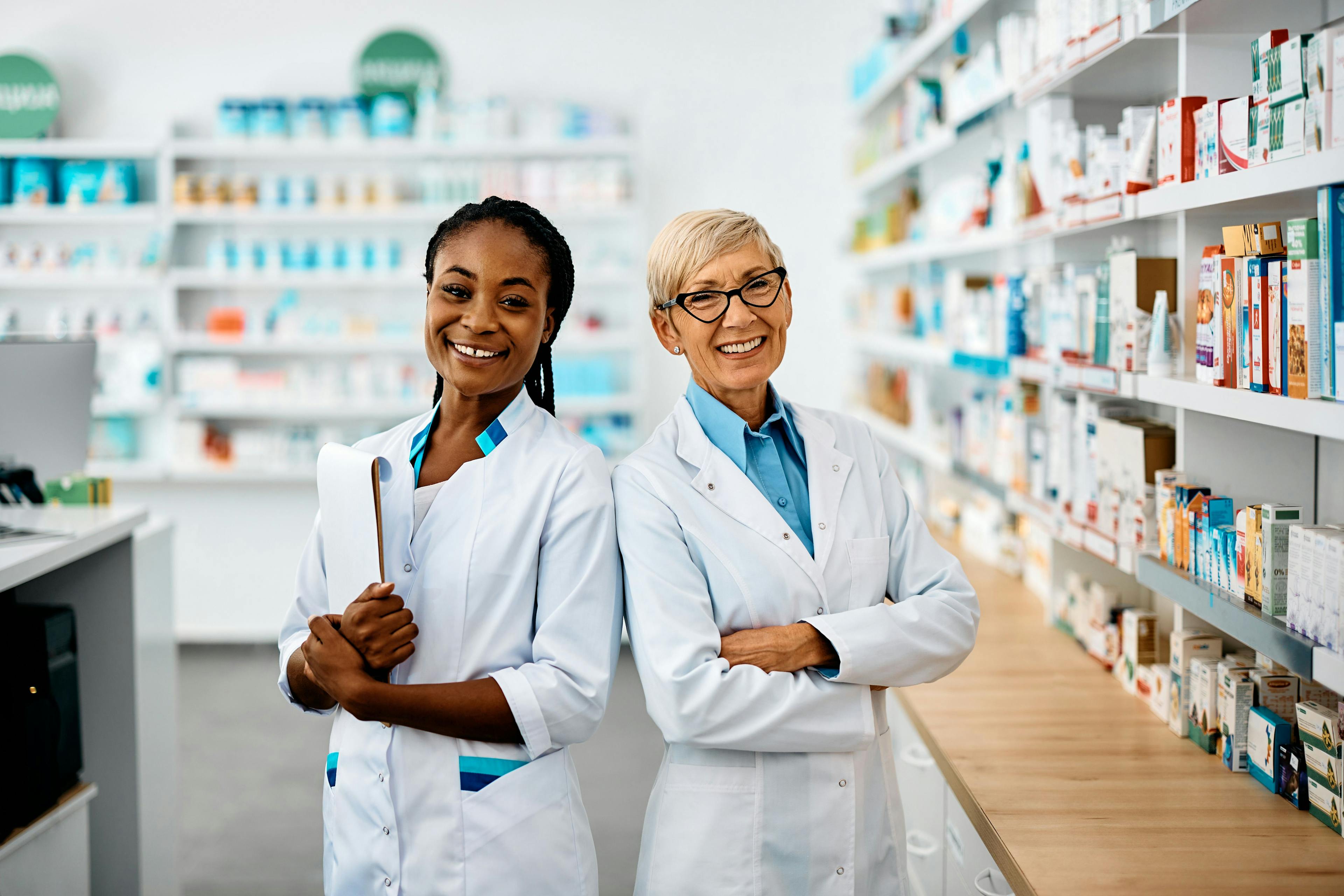 Portrait of happy female pharmacists in pharmacy looking at camera