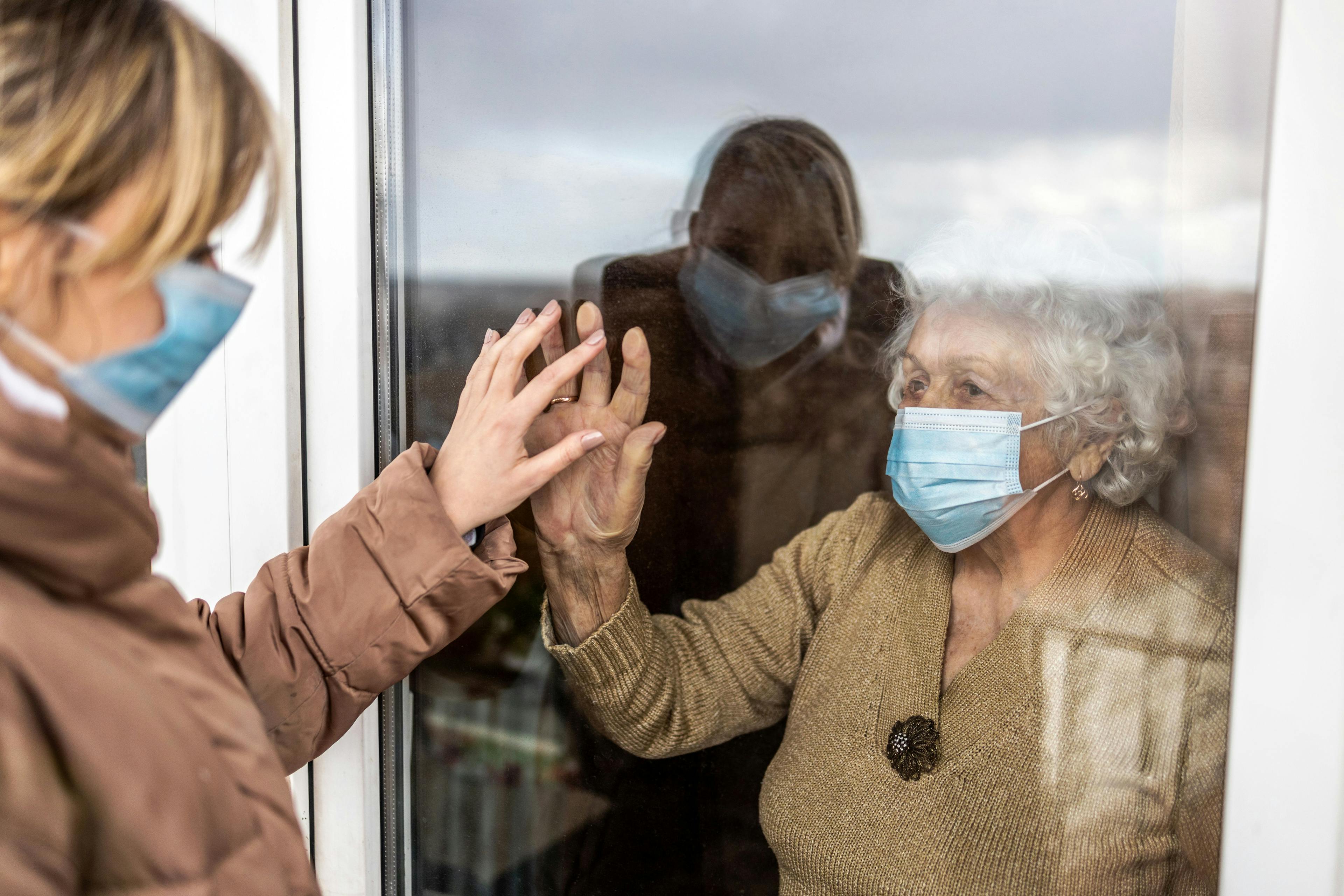 Woman visiting her grandmother in isolation during a coronavirus pandemic | Image credit: Pikselstock - stock.adobe.com