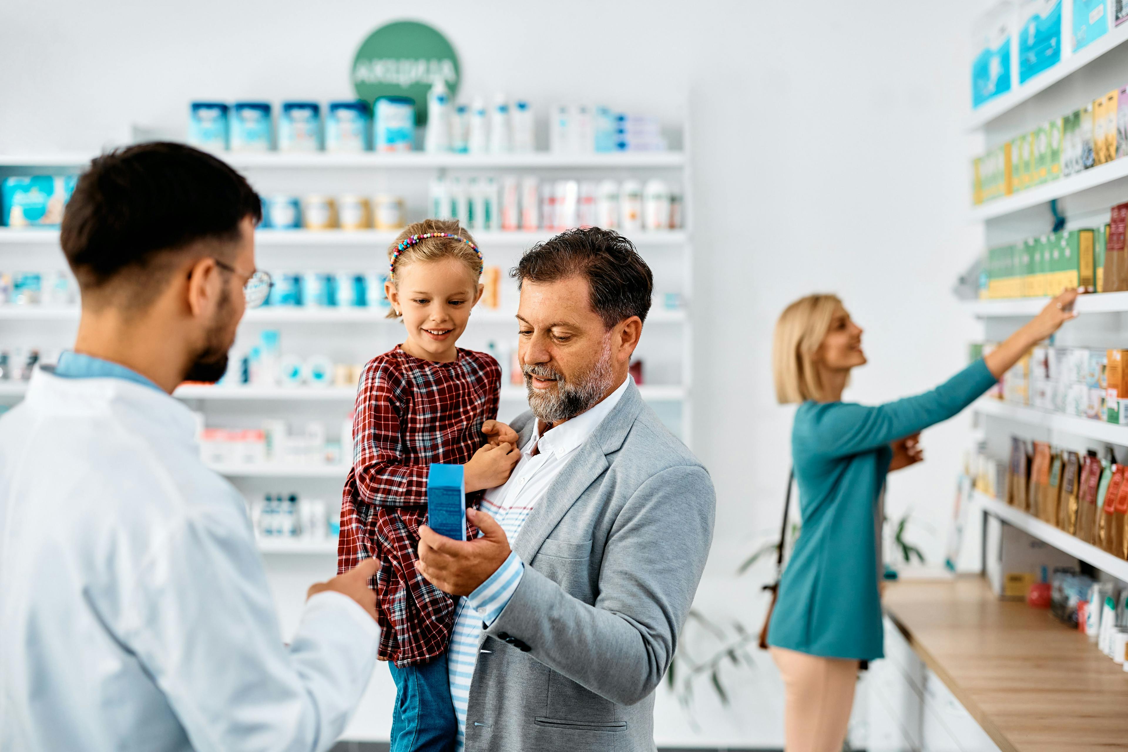 Father and daughter buying in drugstore with help of pharmacist. | Image Credit: Drazen - stock.adobe.com