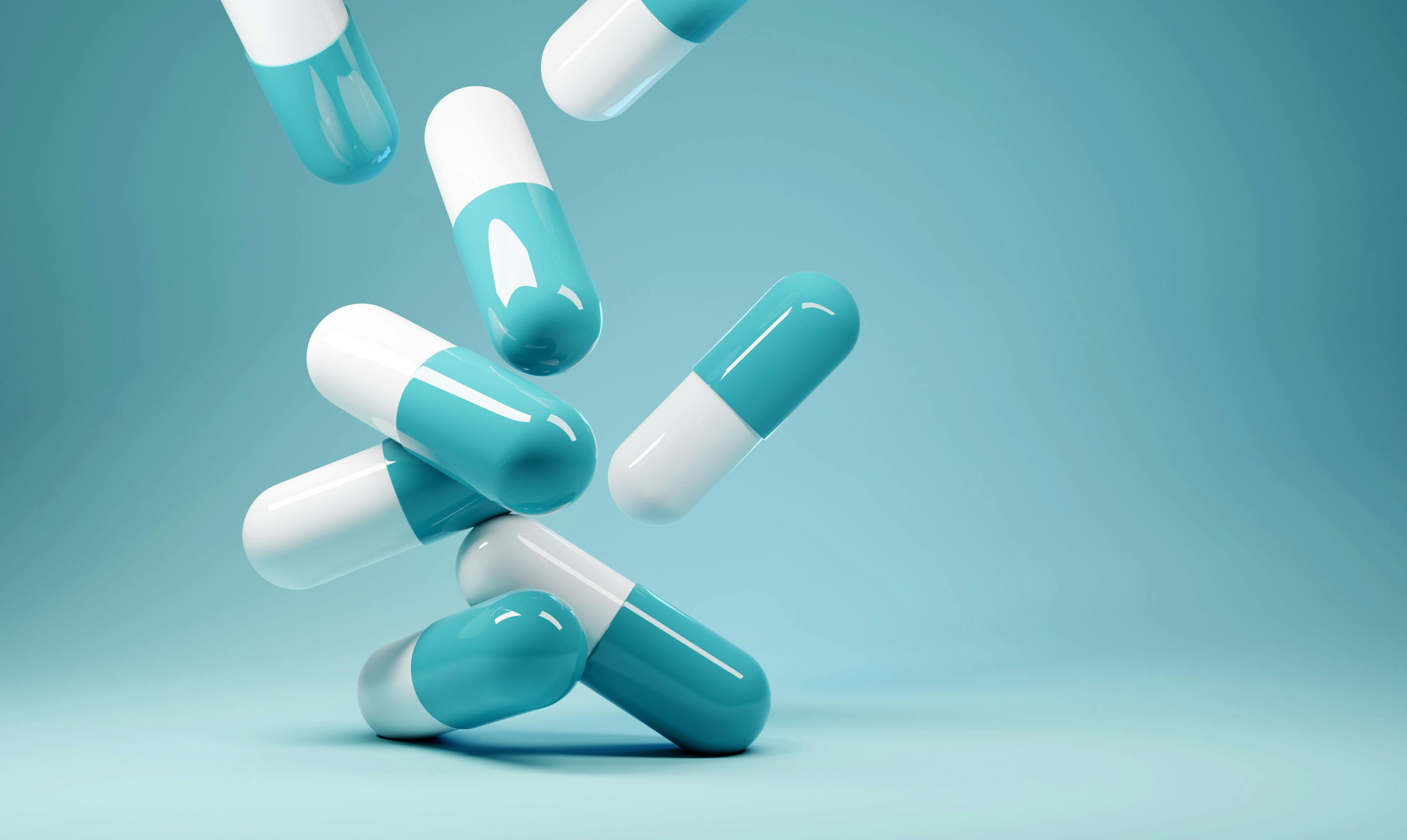 A group of antibiotic pill capsules falling. Healthcare and medical 3D illustration background | Image credit: James Thew - stock.adobe.com