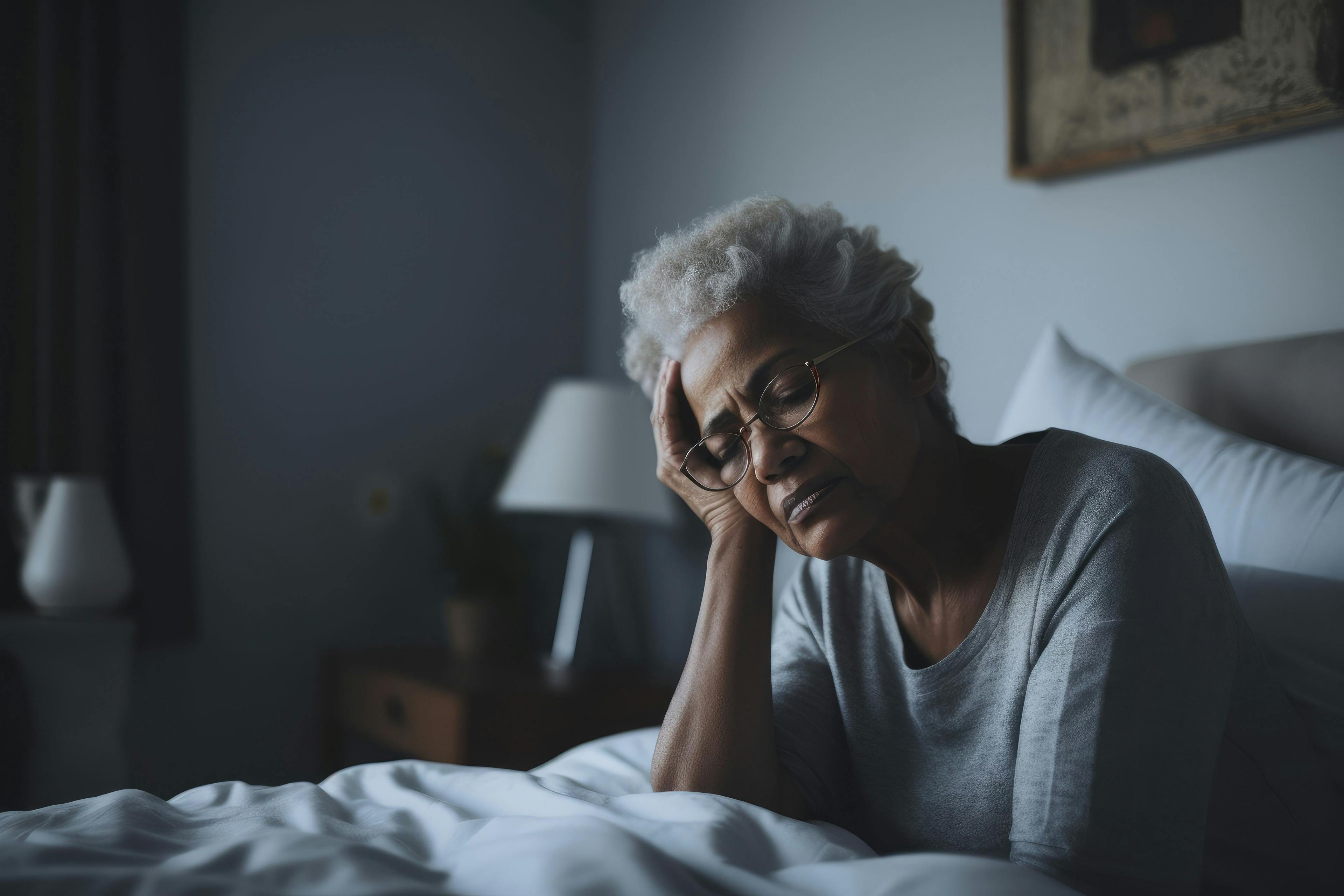 Senior woman having a headache and feeling sick in the bedroom at home - Image credit: Baba Images | stock.adobe.com
