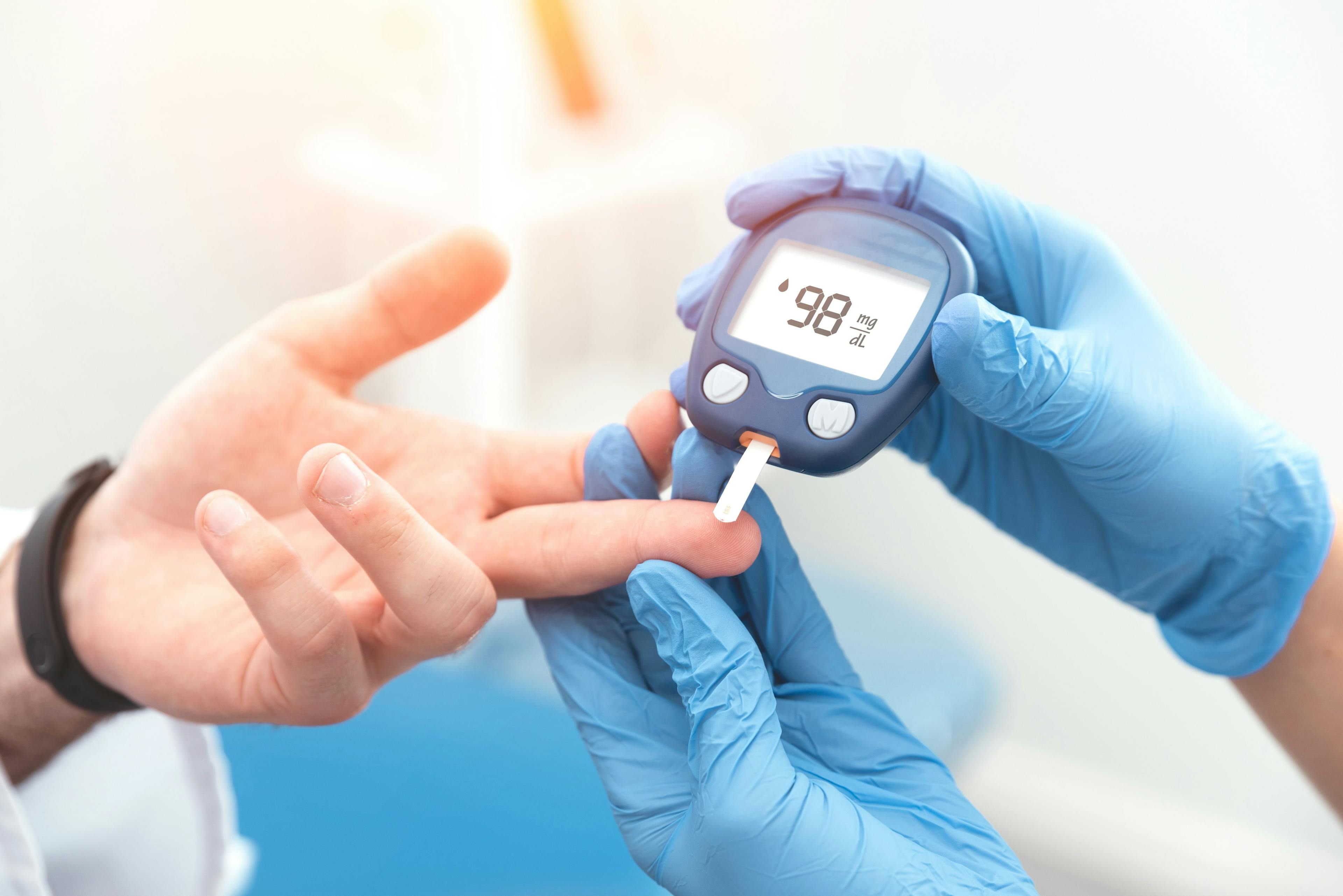 Health care worker testing a patient's blood sugar level