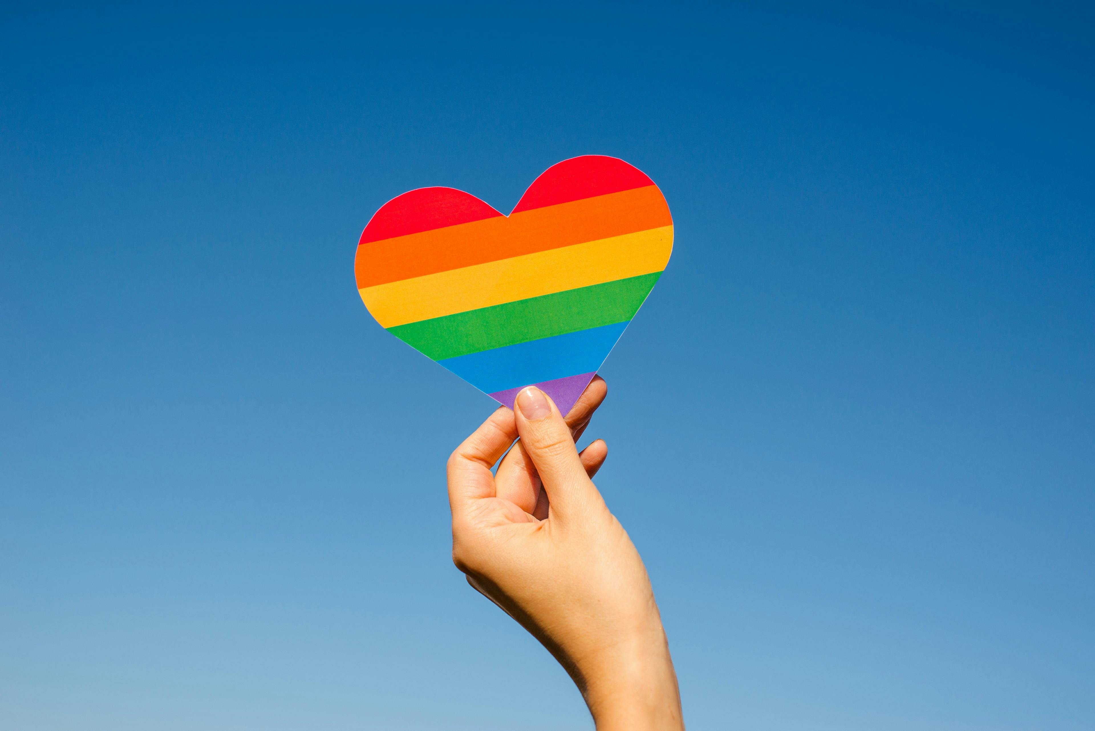 Woman holding a rainbow heart for Pride Month | Image credit: Iuliia Pilipeichenko - stock.adobe.com