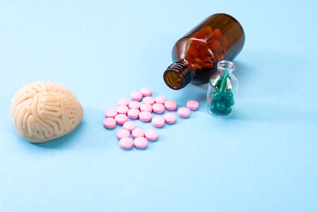 Brain on a blue background with white pills in a glass bottle. Some pills for the brain. Symbolical for medicines, psychopharmaceuticals, nootropics and other medicines. Medicine. Brain treatment - Image credit: Natallia | stock.adobe.com