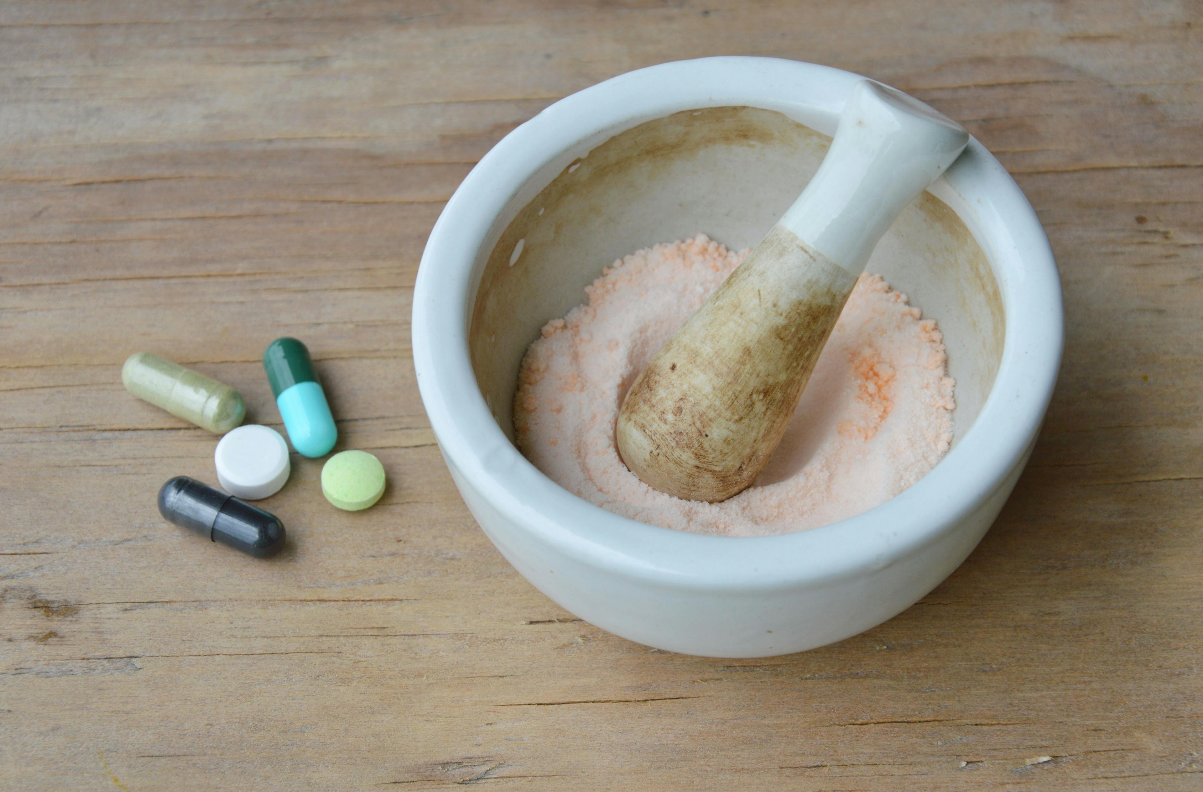 mortar and pestle for crushed pill on wooden board