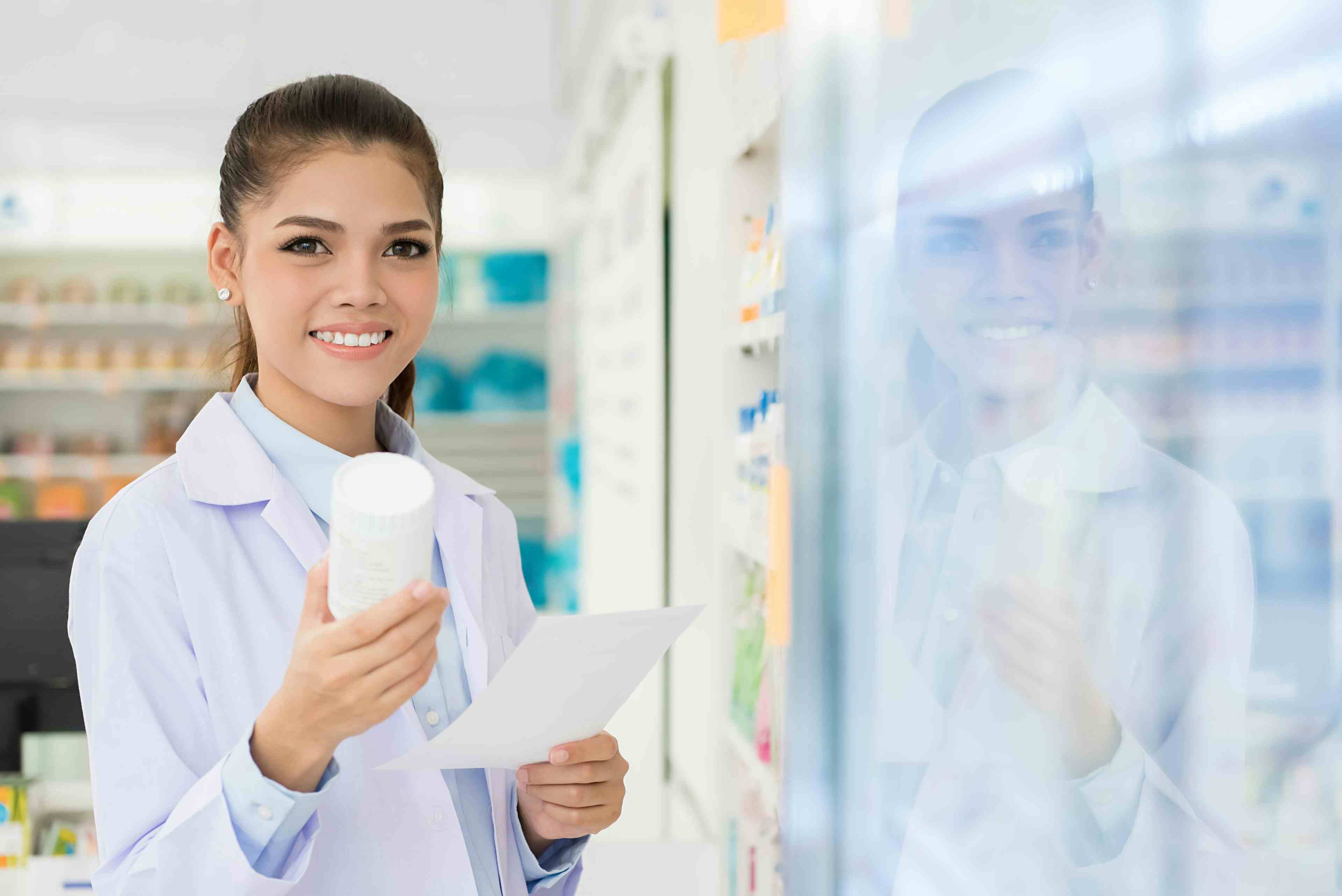 Smiling Asian female pharmacist working in chemist shop or pharmacy | Image Credit: Atstock Productions - stock.adobe.com
