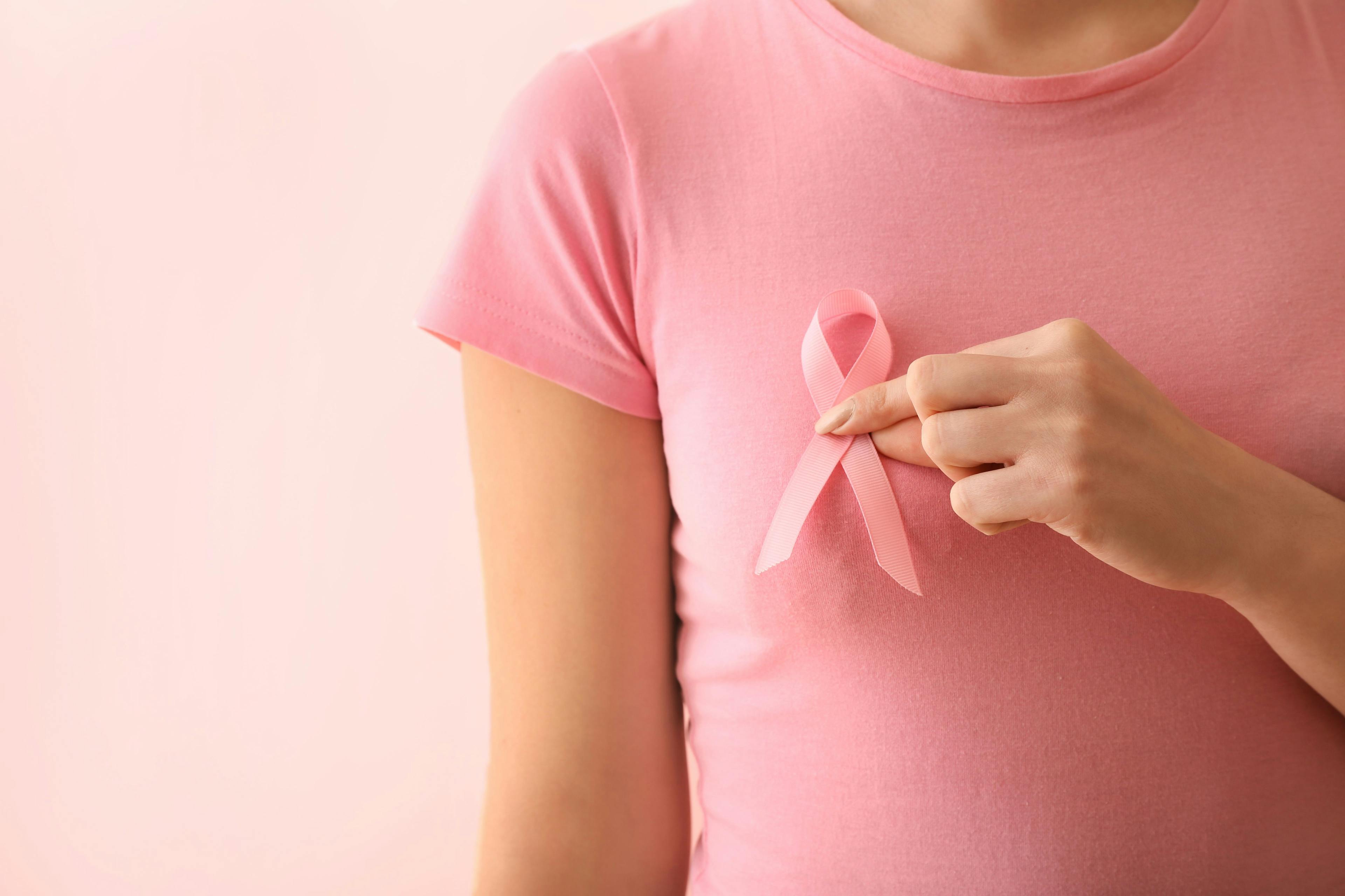 Woman holding a pink ribbon for breast cancer awareness