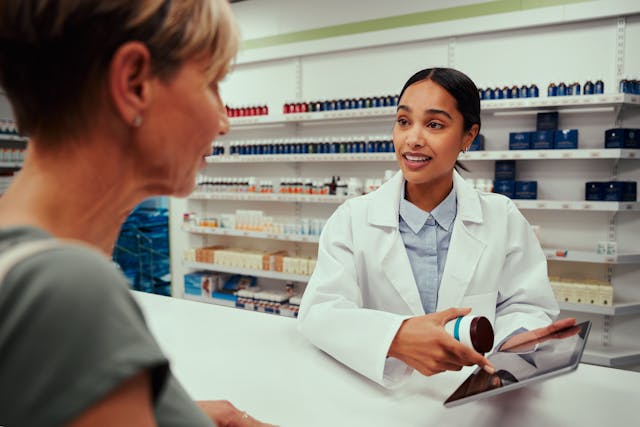 Pharmacist discussing medication with a patient -- Image credit: StratfordProductions | stock.adobe.com