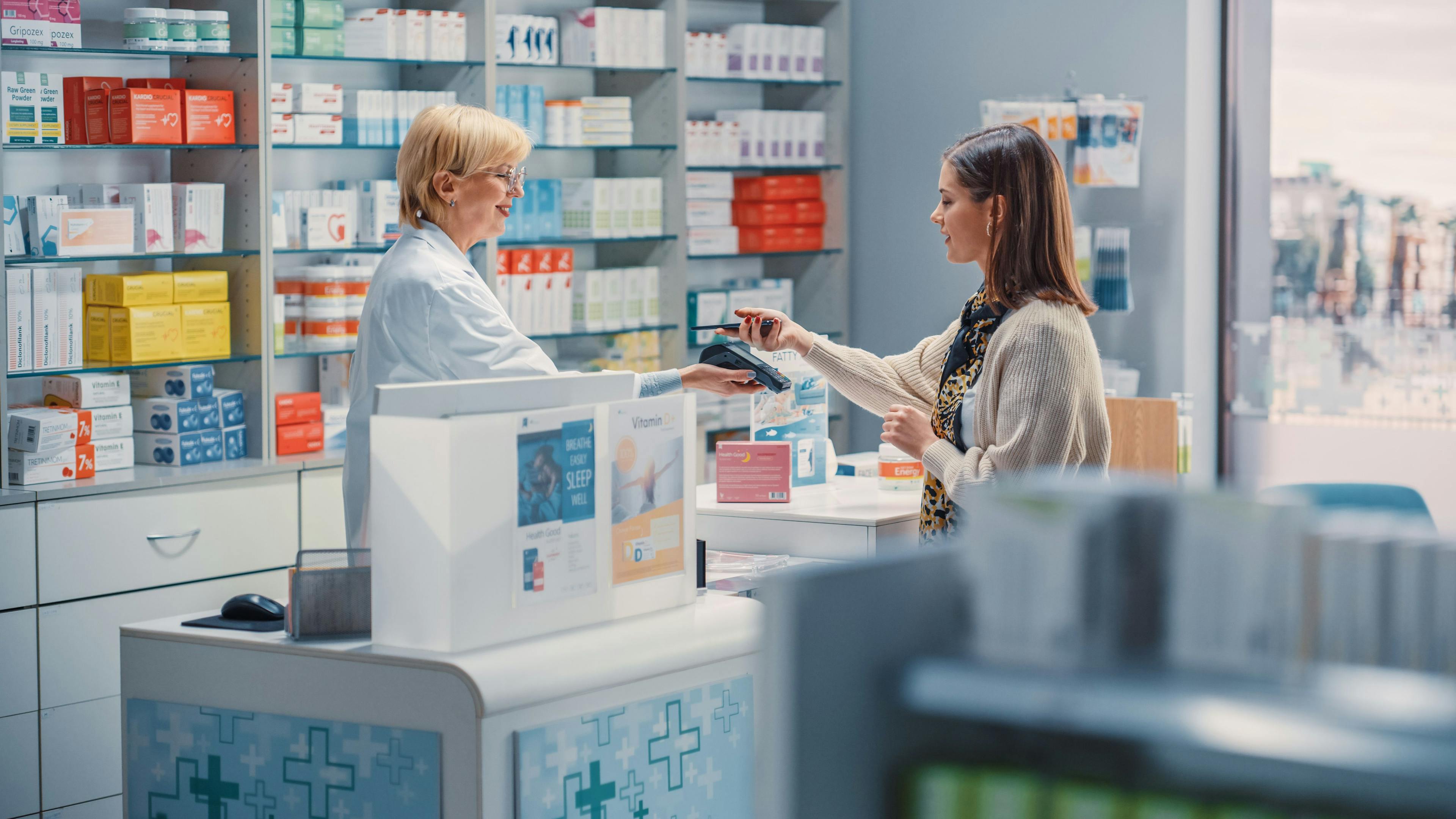 Female Pharmacist and Young Woman Using Contactless Payment | Image Credit: Gorodenkoff - stock.adobe.com