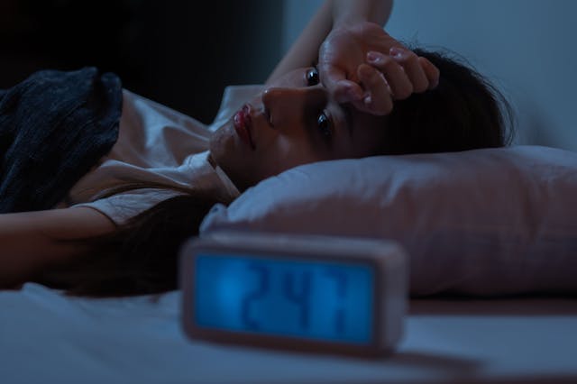 Woman struggling with insomnia -- Image credit: pitipat | stock.adobe.com